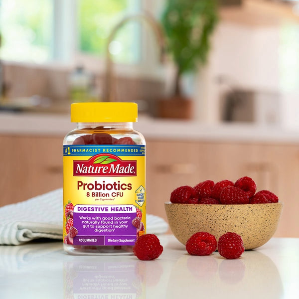 Nature Made Probiotics bottle with raspberries on a kitchen counter