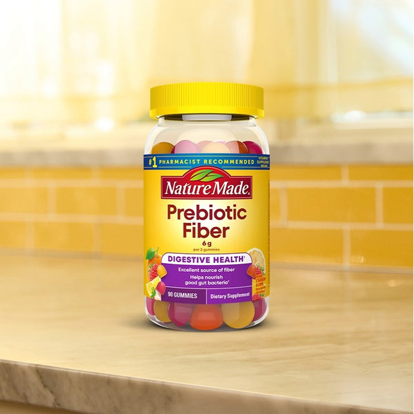 Nature Made Prebiotic Fiber gummies on a kitchen counter with a yellow tiled backsplash.