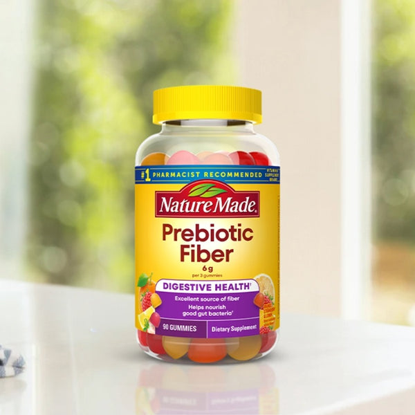 Nature Made Prebiotic Fiber supplement bottle on a white surface with a blurred green background