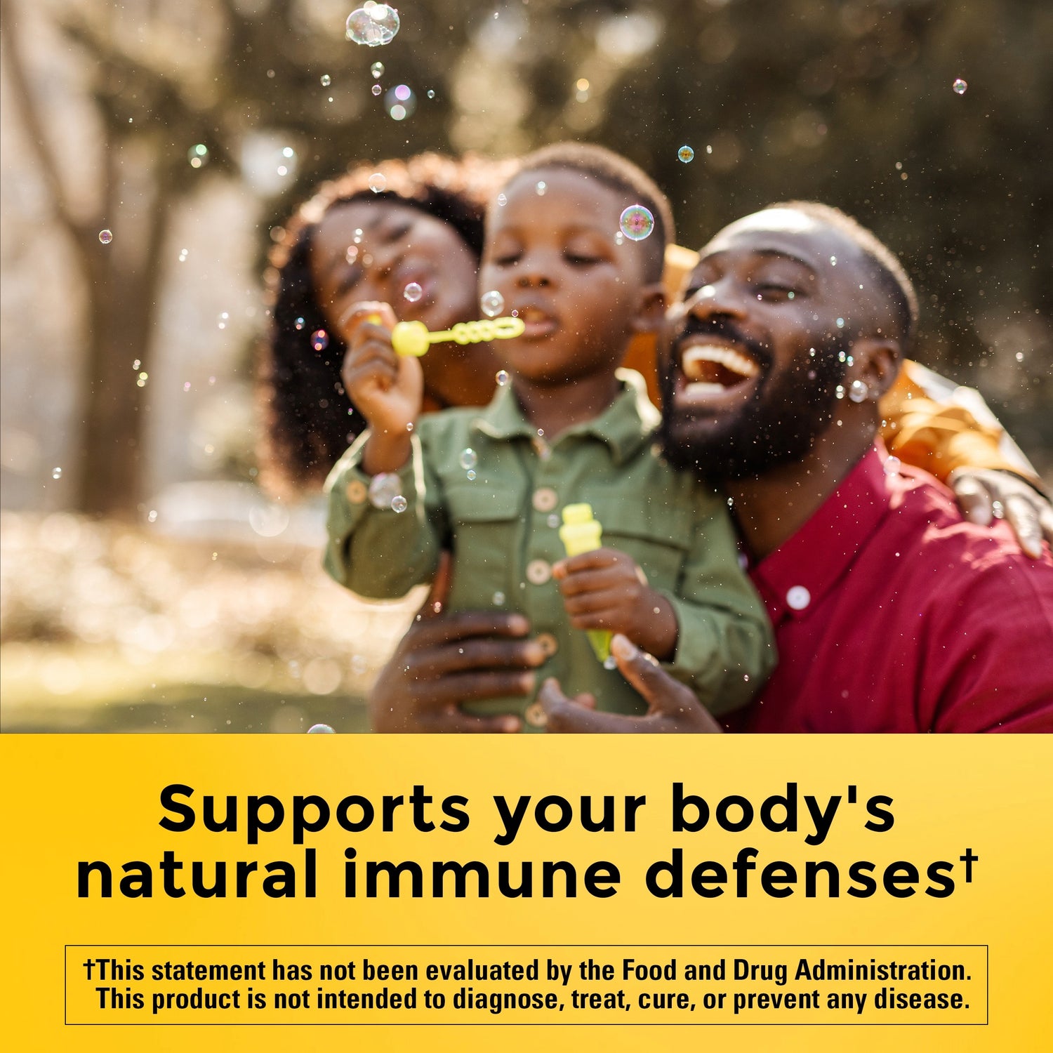 Vitamin E 400 IU (180 mg) dl-Alpha Softgels | Family blowing bubbles outdoors with supports your body's natural immune defenses text on a yellow background.