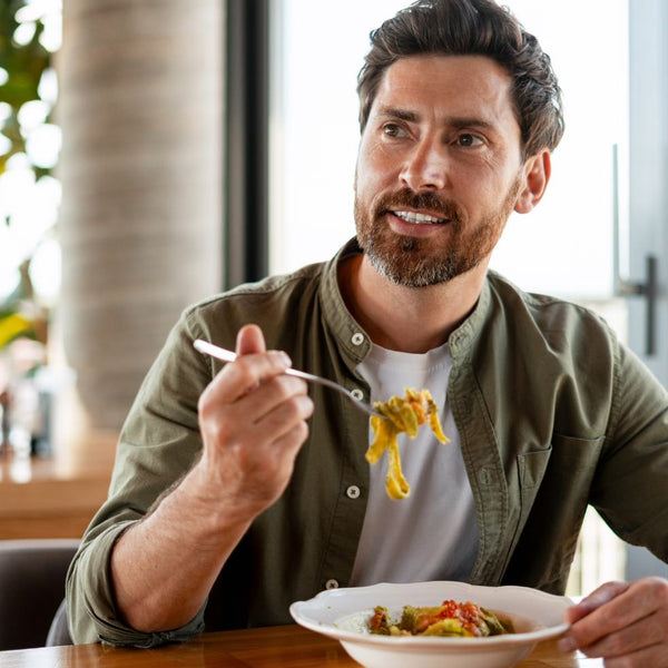 Person in green shirt eating a meal indoors